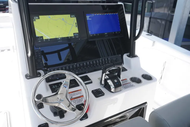 Slide: The Image of 2023 Twin Vee 280 GFX CC boat dashboard with navigation screens and steering wheel. - 20