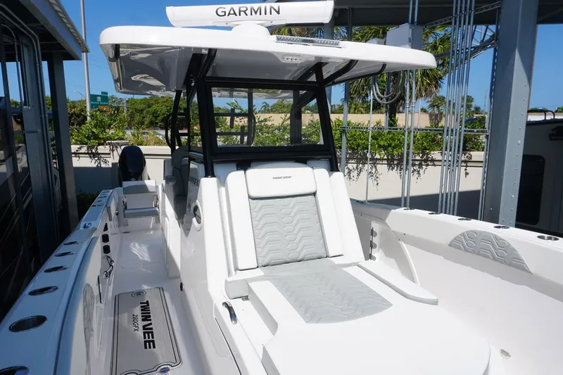 Slide: The Image of 2023 Twin Vee 280 GFX CC boat with Garmin equipment, featuring sleek white seating. - 23