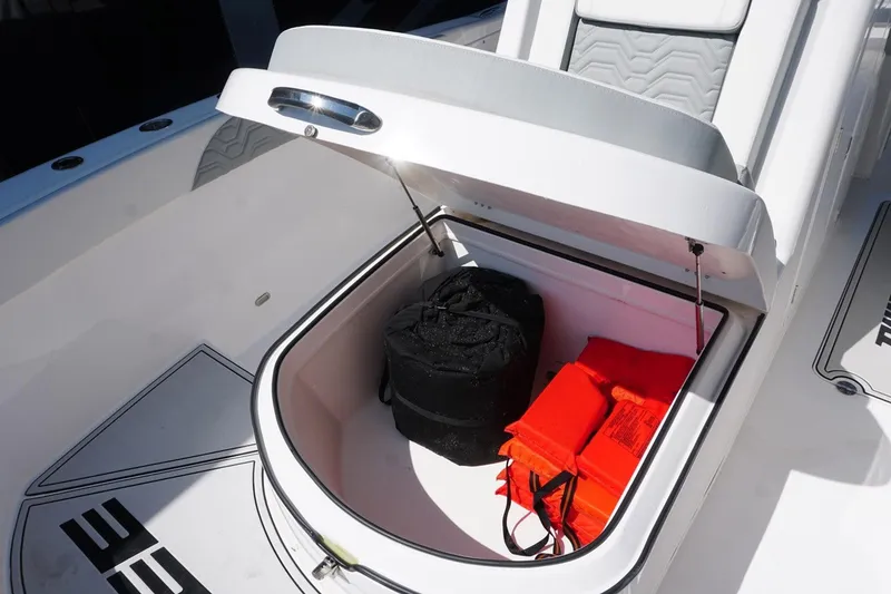 Slide: The Image of 2023 Twin Vee 280 GFX CC boat storage compartment with life jackets and gear. - 25