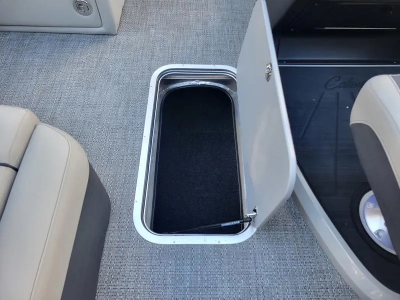 Slide: The Image of Barletta C22Q 2025 boat storage compartment with open hatch on carpeted floor. - 20
