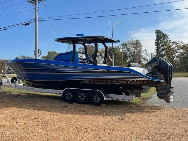 Slide: The Image of 2022 Fountain 39 NX boat on trailer, blue and black design, parked outdoors. - 3