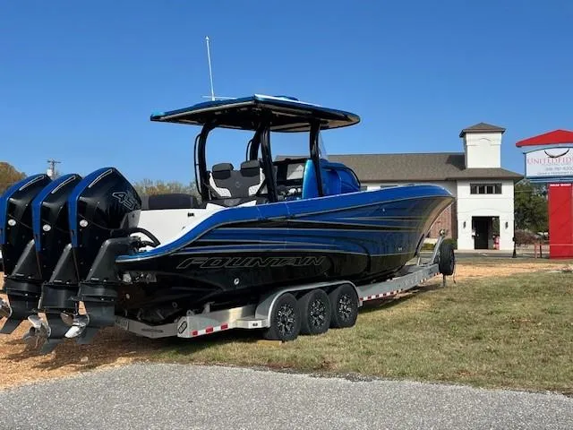 Slide: The Image of 2022 Fountain 39 NX boat on trailer with triple engines, parked outdoors. - 5