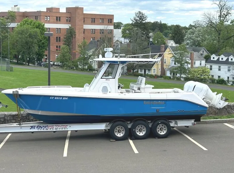 Slide: The Image of 2015 Everglades 295 Center Console boat on a trailer in a parking lot. - 0
