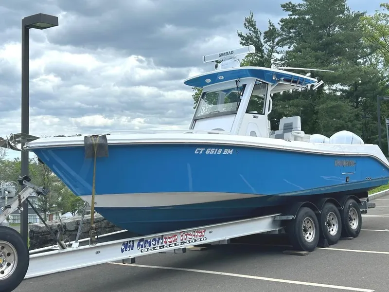 Slide: The Image of 2015 Everglades 295 Center Console boat on a trailer, parked outdoors. - 2