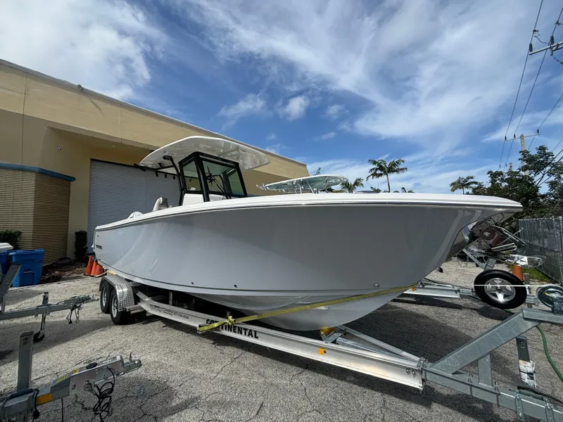 Slide: The Image of 2025 Sailfish 272 CC boat on trailer, parked outdoors under a cloudy sky. - 1