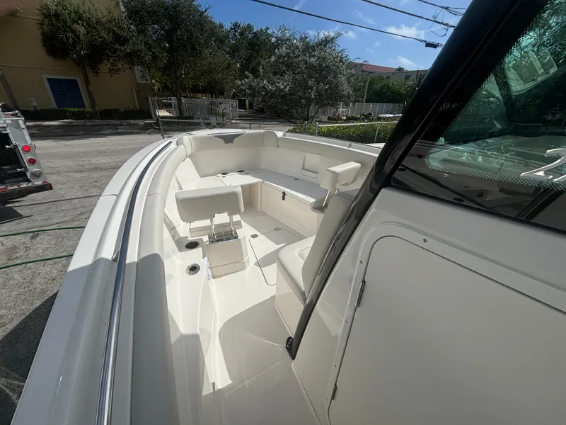 Slide: The Image of 2025 Sailfish 272 CC boat interior with seating and console, parked outdoors. - 13