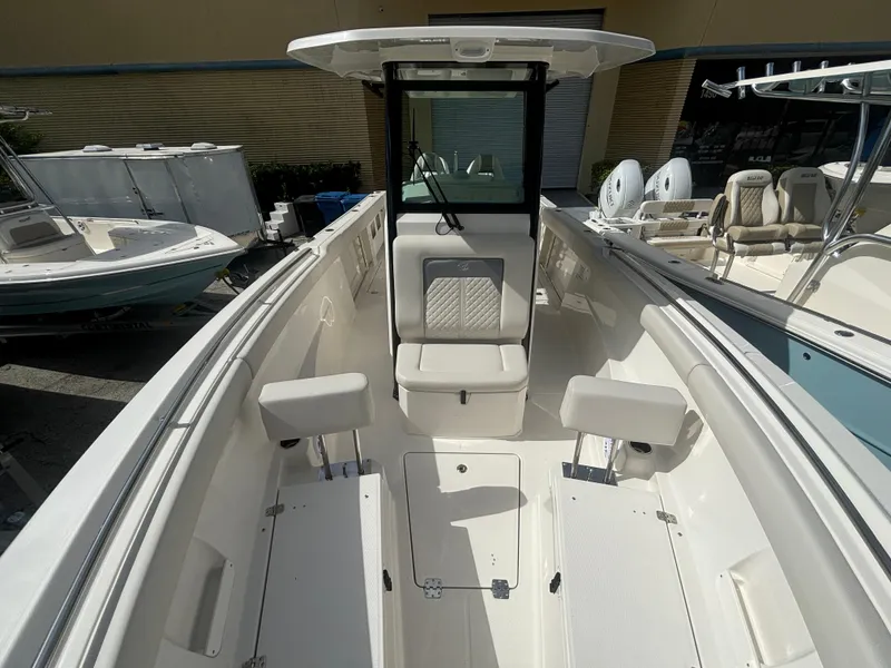Slide: The Image of 2025 Sailfish 272 CC boat interior with seating and console, docked outdoors. - 17
