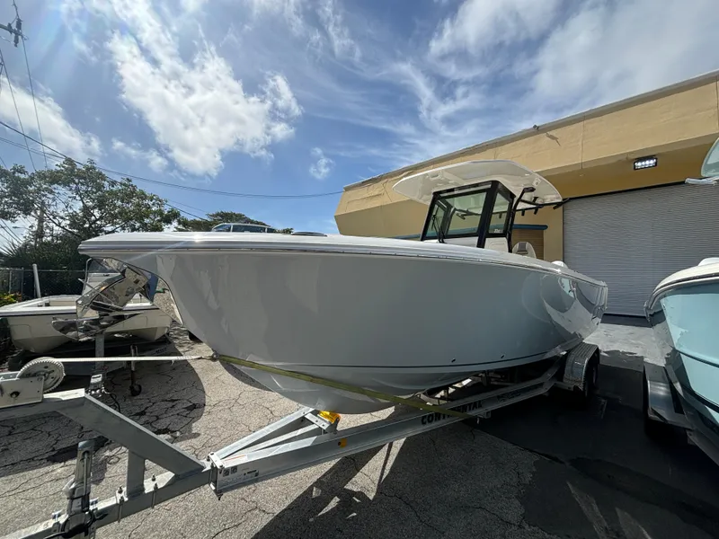 Slide: The Image of 2025 Sailfish 272 CC boat on trailer under a partly cloudy sky. - 2