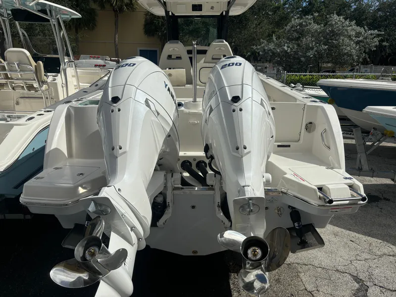 Slide: The Image of 2025 Sailfish 272 CC boat with twin outboard engines, docked outdoors. - 4