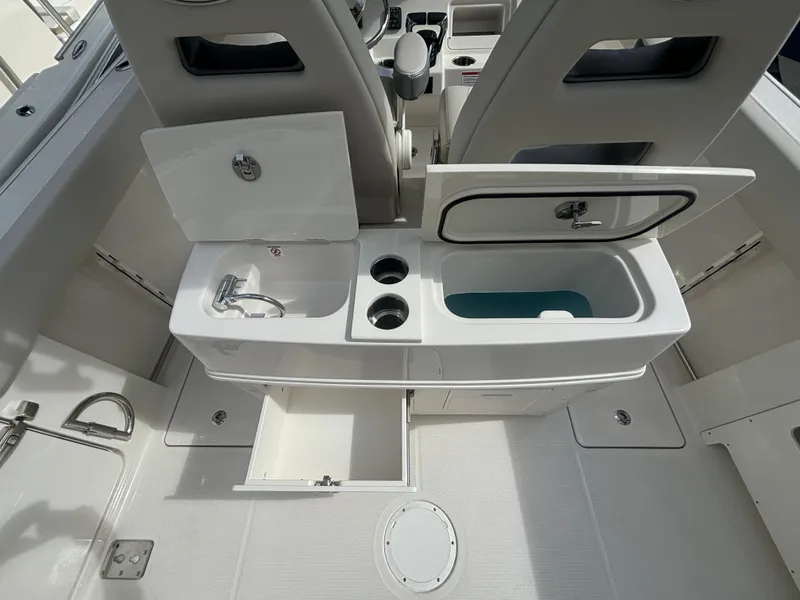 Slide: The Image of 2025 Sailfish 272 CC boat interior with open storage compartments and sink. - 7