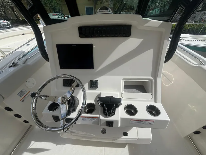 Slide: The Image of 2025 Sailfish 272 CC boat console with steering wheel and control panel. - 9