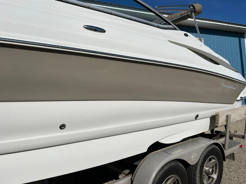 Slide: The Image of 2006 Crownline 260 LS boat on trailer, side view, white and beige exterior. - 17