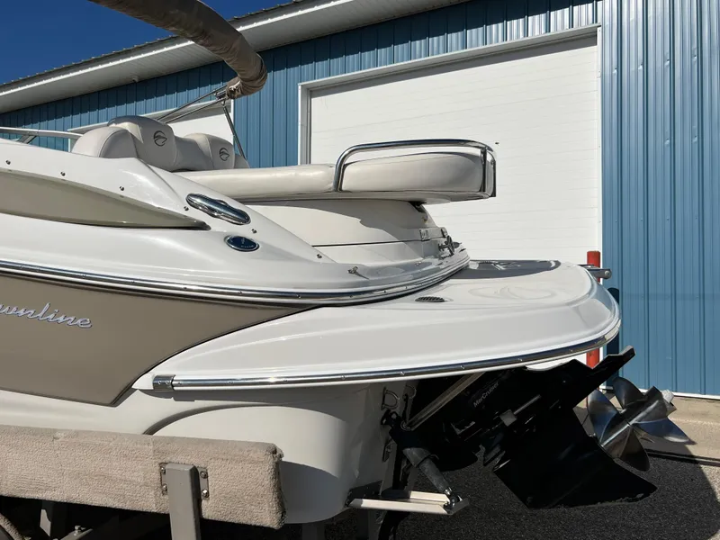 Slide: The Image of 2006 Crownline 260 LS boat stern view with propeller, parked near blue building. - 20