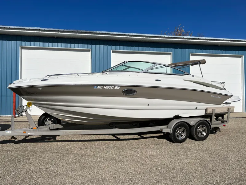 Slide: The Image of 2006 Crownline 260 LS boat on trailer, parked outside blue garage. - 21