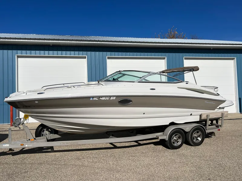 Slide: The Image of 2006 Crownline 260 LS boat on trailer, parked outside blue garage. - 22