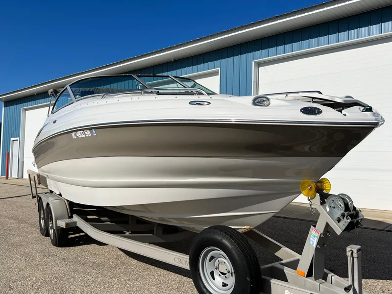 Slide: The Image of 2006 Crownline 260 LS boat on trailer, parked outside blue building. - 23
