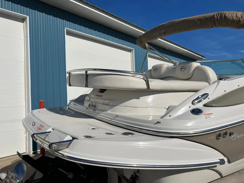 Slide: The Image of 2006 Crownline 260 LS boat with sleek design, docked near blue building. - 28