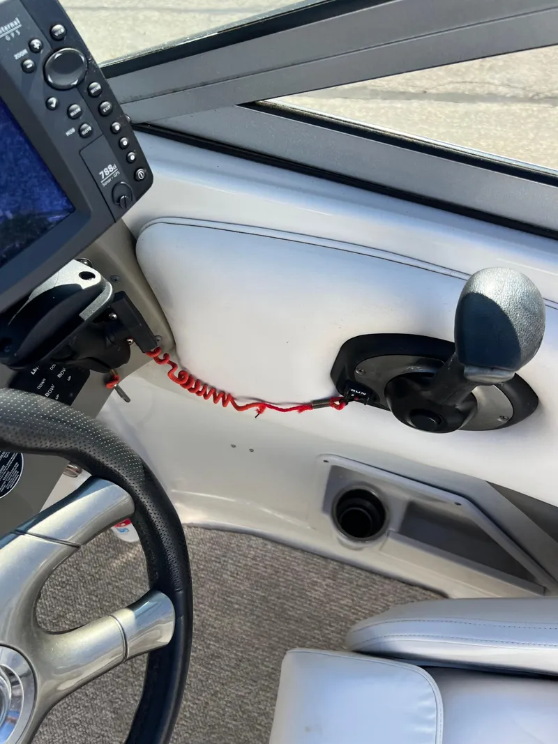 Slide: The Image of 2006 Crownline 260 LS boat cockpit with steering wheel and control panel. - 48