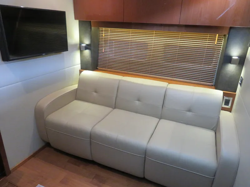 Slide: The Image of Luxurious interior of 2015 Sea Ray 470 Sundancer with beige sofa and wall-mounted TV. - 18
