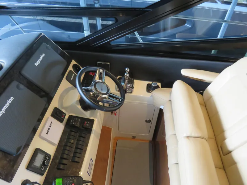 Slide: The Image of 2015 Sea Ray 470 Sundancer helm with Raymarine electronics and beige seating. - 5