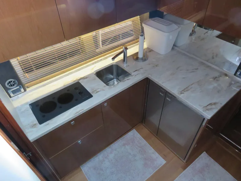 Slide: The Image of Modern kitchen in 2015 Sea Ray 470 Sundancer yacht with marble countertops and stove. - 7