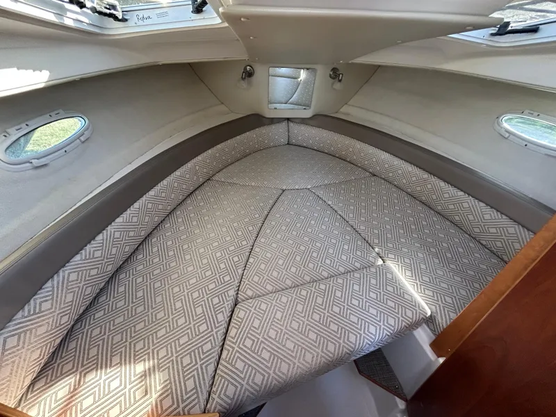 Slide: The Image of 2021 Cutwater C-24 Coupe cabin interior with patterned cushions and porthole windows. - 10