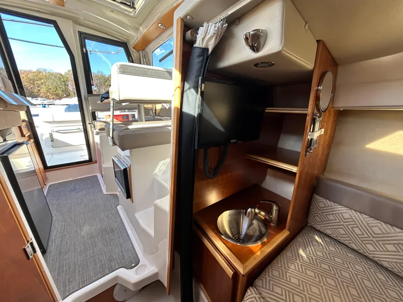 Slide: The Image of Interior of 2021 Cutwater C-24 Coupe, featuring seating, sink, and TV. - 11