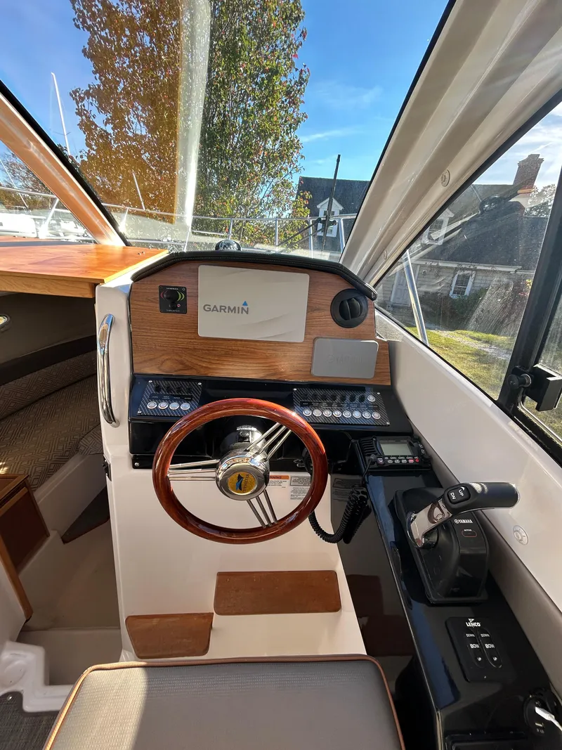 Slide: The Image of 2021 Cutwater C-24 Coupe helm with Garmin navigation, wooden accents, and modern controls. - 5