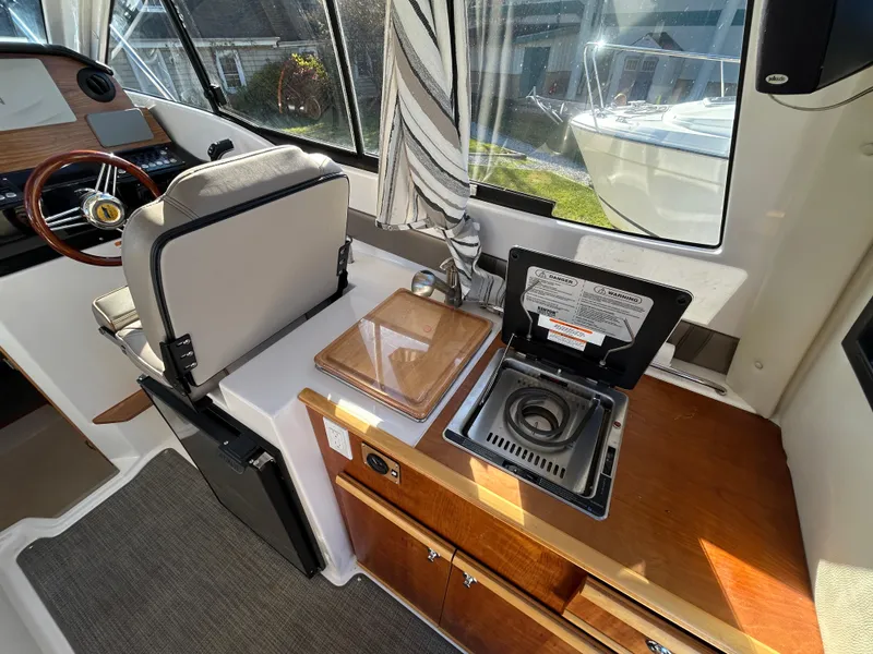 Slide: The Image of 2021 Cutwater C-24 Coupe interior with kitchenette and helm station. - 7