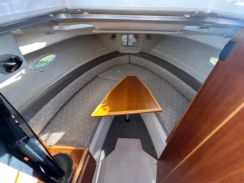 Slide: The Image of 2021 Cutwater C-24 Coupe cabin interior with cozy seating and wooden table. - 9