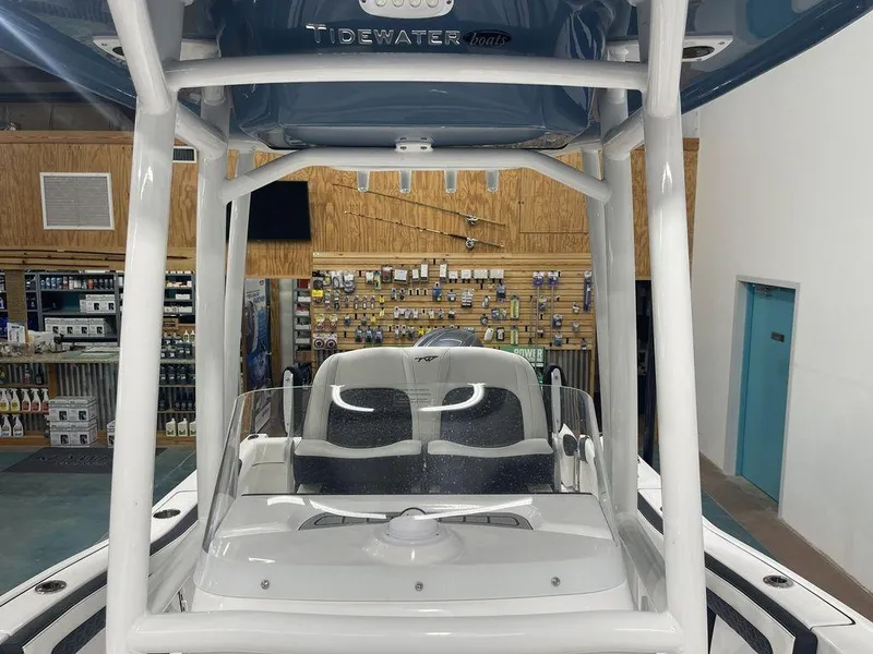 Slide: The Image of 2025 Tidewater 210 LXF boat interior with seating and console in showroom. - 9