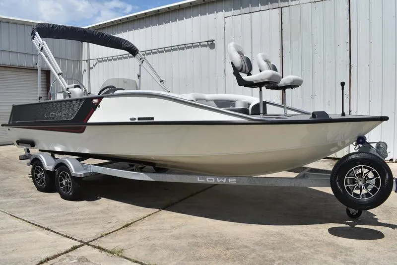 Slide: The Image of 2025 Lowe SD224 boat on trailer, parked outdoors, featuring sleek design and modern seating. - 1