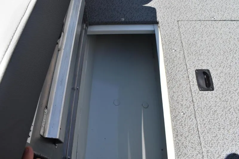Slide: The Image of Storage compartment on a 2025 Lowe SD224 boat, featuring a textured gray surface. - 22