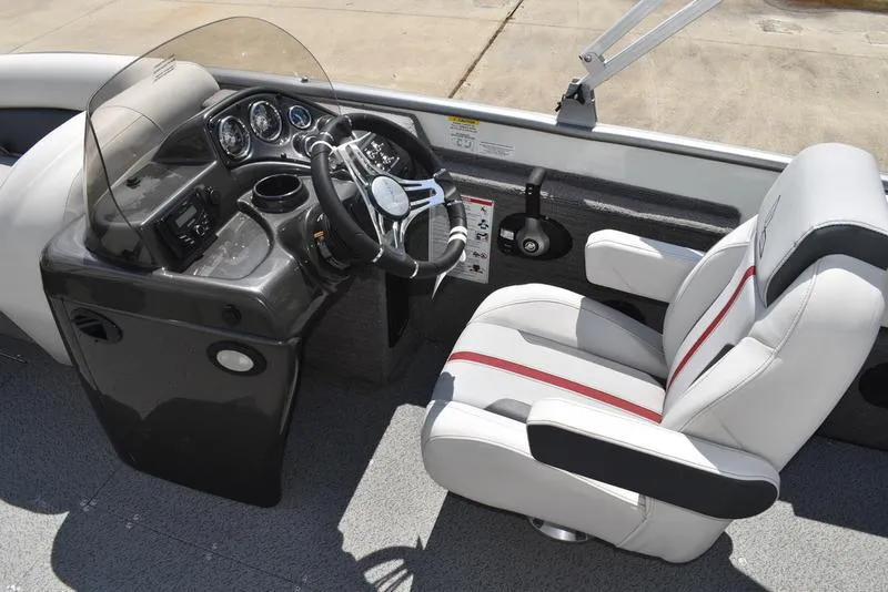 Slide: The Image of 2025 Lowe SD224 boat cockpit with steering wheel, dashboard, and white captain's chair. - 30