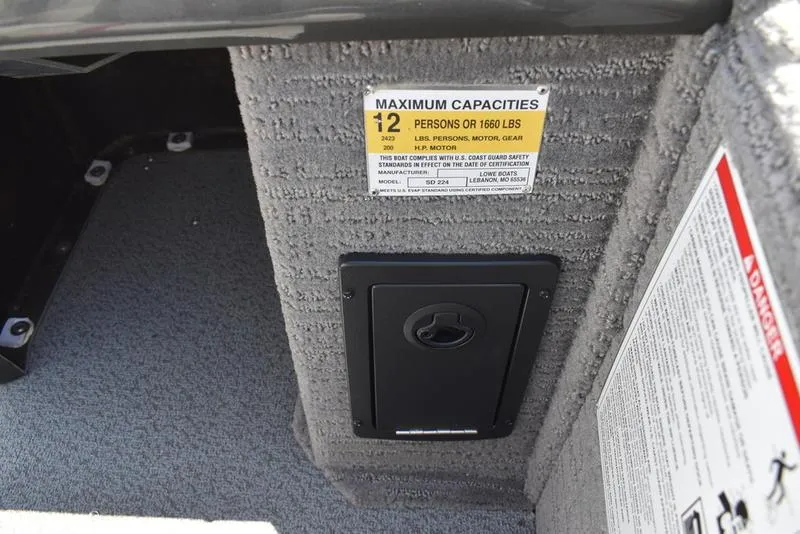 Slide: The Image of Interior of Lowe SD224 boat showing capacity label and storage compartment. - 34