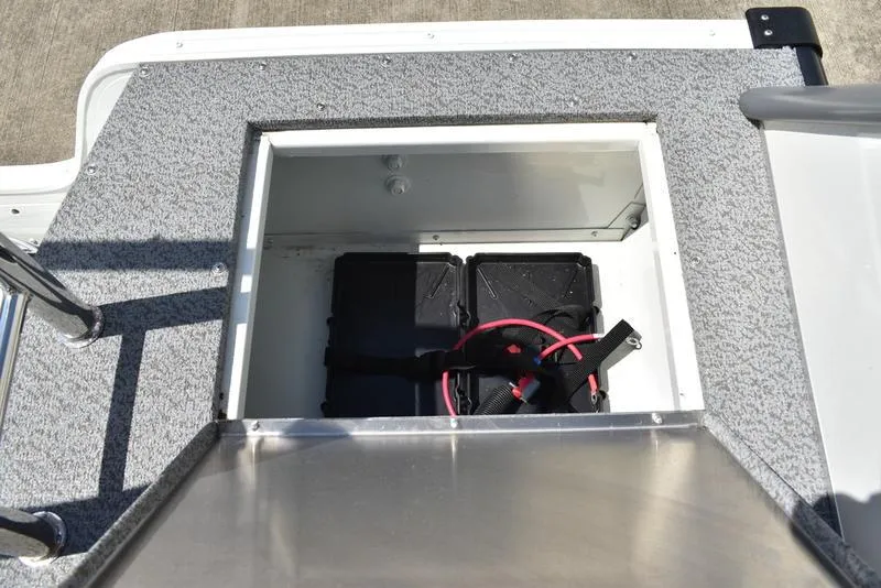 Slide: The Image of Battery compartment of 2025 Lowe SD224 boat with red cables and secure straps. - 41