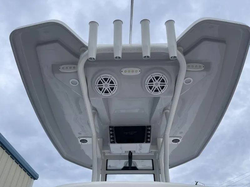 Slide: The Image of Tidewater 232cc 2025 boat T-top with speakers and rod holders against cloudy sky. - 11