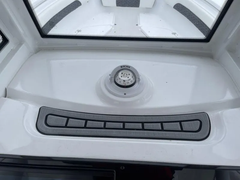 Slide: The Image of 2025 Tidewater 232cc boat dashboard with compass and control panel. - 17