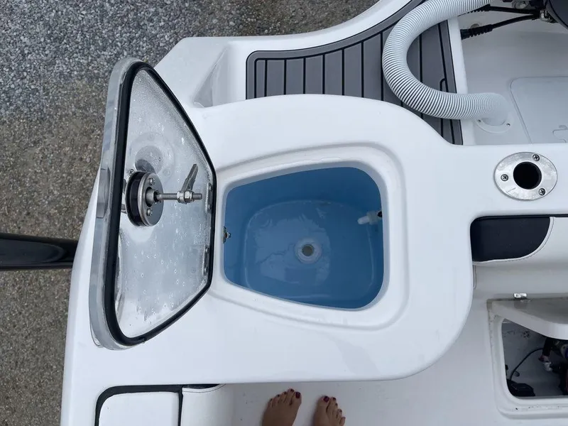 Slide: The Image of Tidewater 232cc 2025 boat livewell with open lid and water inside. - 34