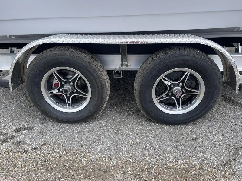 Slide: The Image of Trailer wheels for 2025 Tidewater 232cc boat on gravel surface. - 42