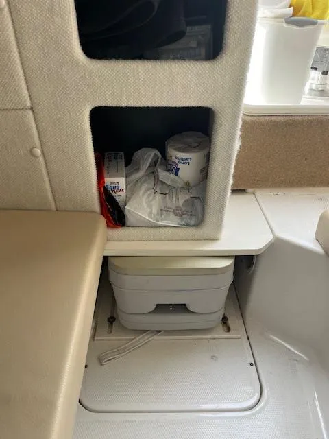 Slide: The Image of 2013 Chaparral 225 SSi boat interior storage with supplies and portable toilet. - 14