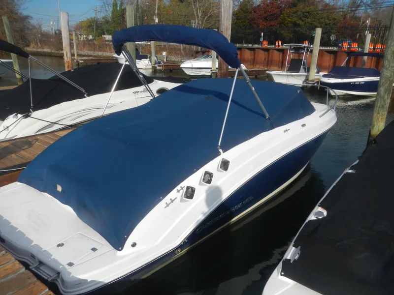 Slide: The Image of 2013 Chaparral 225 SSi boat docked with blue cover and canopy. - 3