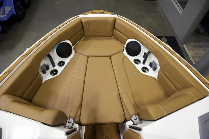 Slide: The Image of 2025 Malibu 26 LSV boat interior with tan leather seating and built-in speakers. - 16