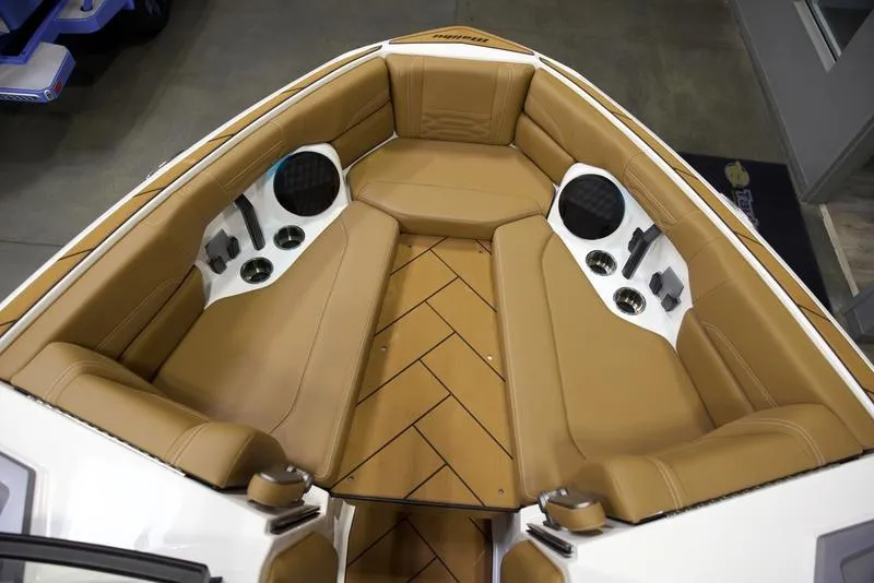 Slide: The Image of 2025 Malibu 26 LSV boat interior with tan seating and built-in speakers. - 22