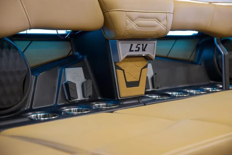 Slide: The Image of Interior of 2025 Malibu 26 LSV boat with tan seating and cup holders. - 26