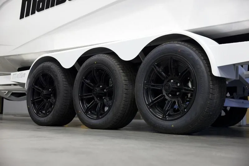 Slide: The Image of 2025 Malibu 26 LSV boat trailer with black wheels, side view. - 34