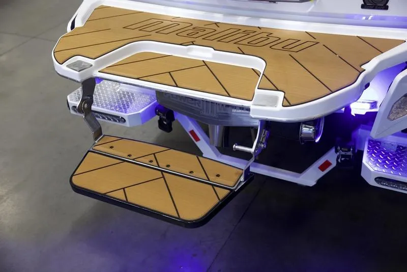 Slide: The Image of 2025 Malibu 26 LSV boat swim platform with LED lights and teak finish. - 5