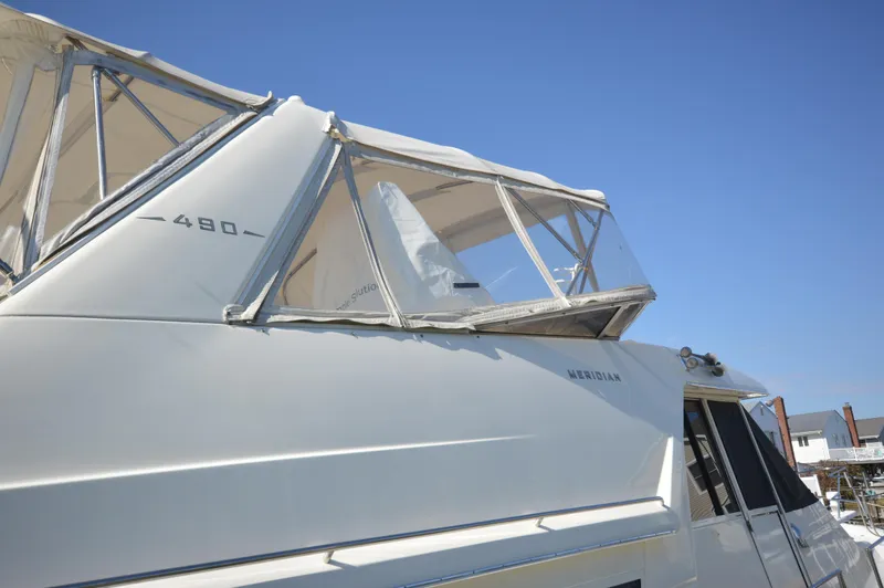 Slide: The Image of 2007 Meridian 490 Pilothouse yacht with clear canopy under blue sky. - 10