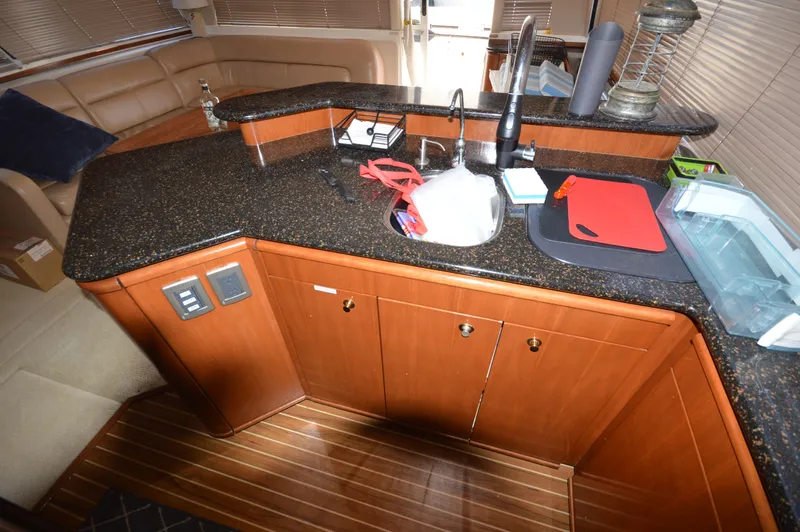 Slide: The Image of 2007 Meridian 490 Pilothouse kitchen with granite countertops and wooden cabinetry. - 21