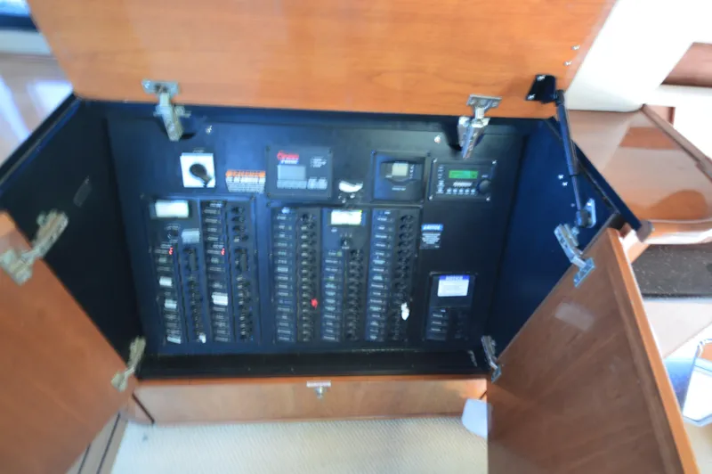 Slide: The Image of Electrical panel inside 2007 Meridian 490 Pilothouse yacht, featuring circuit breakers and control switches. - 24